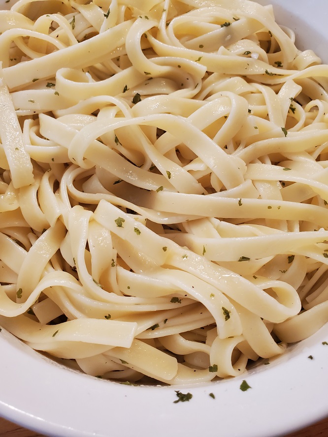 these are fettuccine pasta in a white bowl with authentic alfredo sauce