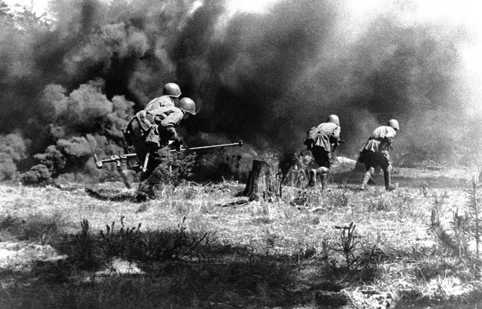 A Russian anti-tank gun crew advances towards the German positions under cover of a smoke screen, somewhere in Russia, on July 23, 1943.