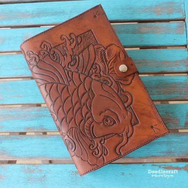 carved tooled leather book cover with asian koi