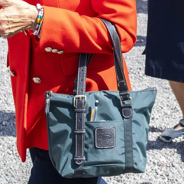 The King arrived at the event field driving his Volvo PV60 car. Queen Silvia wore a red blazer jacket double breasted with gold button