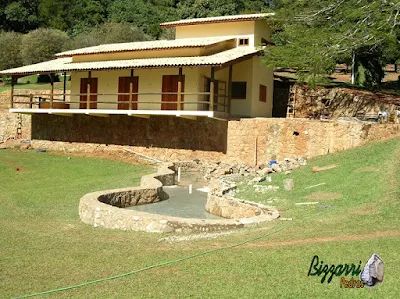 Base de pedra, com pedra moledo, em construção de churrasqueira com o fogão a lenha, o forno de pizza e o lago de carpas em Monte Sião-MG.