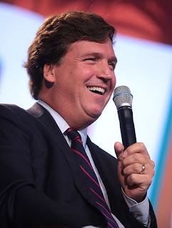 Photo of Tucker Carlson holding a microphone