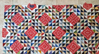 The cream corners are filled with half flowers of red batik and blue centers.