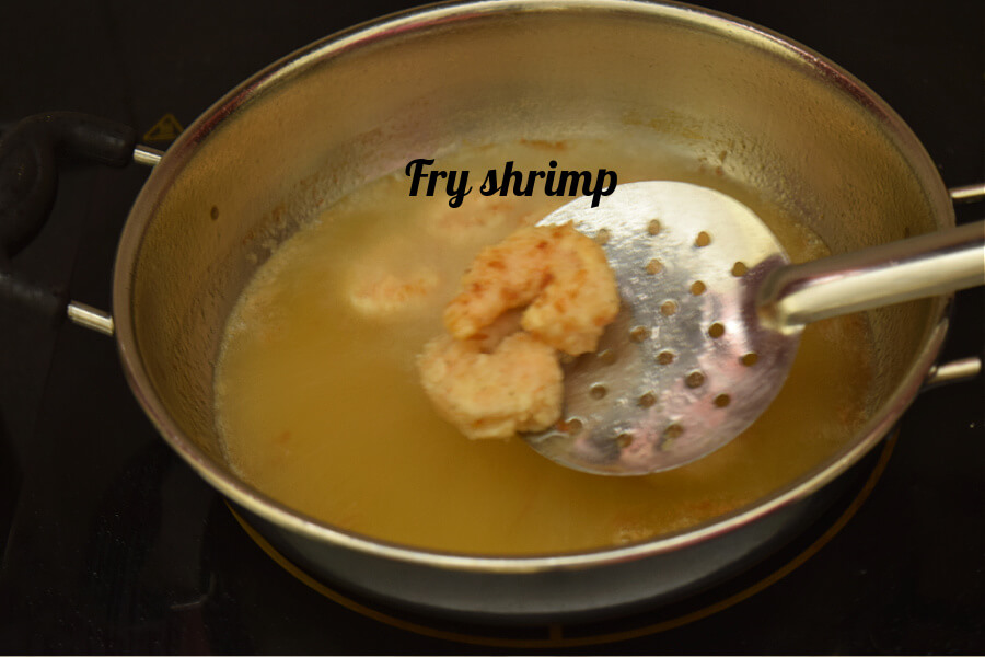 fry shrimp till done - a frying pan with ladle with fried shrimp