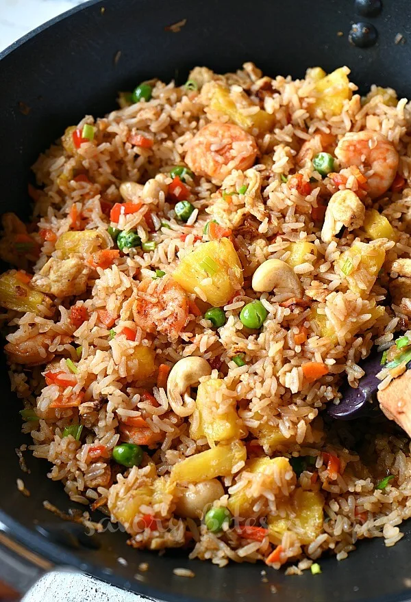 another look of a black wok with homemade authentic thai pineapple fried rice with lots of cashews