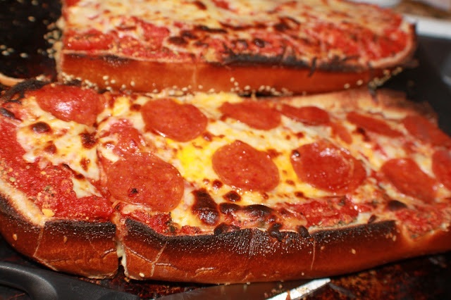 pepperoni and sauce on a split loaf of french bread pizza