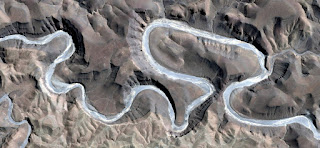 Delusion turquoise snake snaking between the rocks of the African desert like a blue river, abstract African desert landscape from the air, fantasy landscape eroded by water, ghost in the desert, Delusion turquoise snake snaking between the rocks of the African desert like a blue river, abstract African desert landscape from the air,
