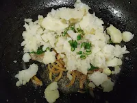 Adding mashed potato and green chili in sauteed onion mixture for aloo paratha stuffing