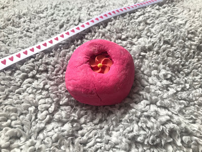 pink lush bubble bar on a grey blanket