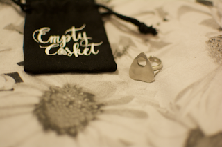 A planchette ring with an empty casket ring bag