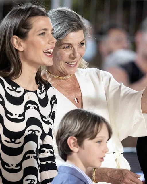 Princess Caroline wore a new wide short sleeve wrap front jumpsuit from Halston. Charlotte Casiraghi wore a new silk crepe dress from Chanel