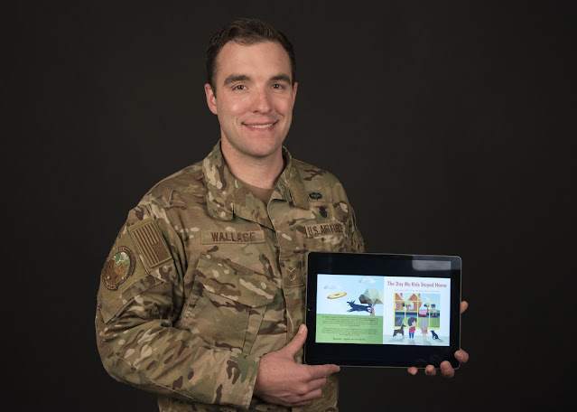 Adam Wallace holding a tablet with one of his books featured.