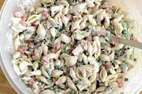 creamy tuna pasta salad in bowl with wooden spoon