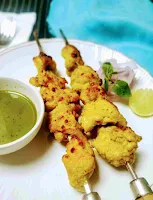 Serving chicken reshmi kabab with green chutney and onion slices