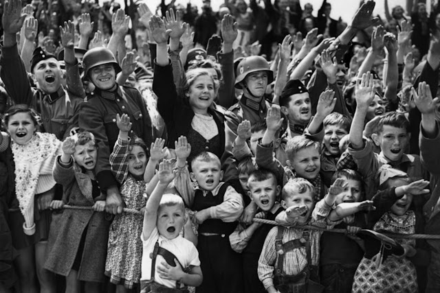 A crowd of women, children and soldiers of the German Wehrmacht give the Nazi salute on June 19, 1940, at an unknown location in Germany. © AP
