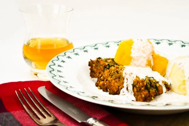 Vegan Haggis & Red Lentil Nut Loaf on a white plate with whisky cream sauce