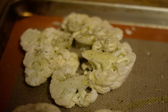 Large cauliflower florets placed together on the baking sheet to make a steak. 