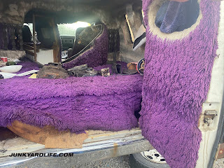 Deep purple shag carpet hangs inside van's rear doors.