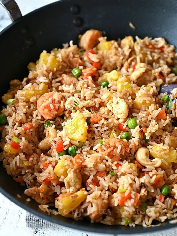 a black wok with pineapple fried rice