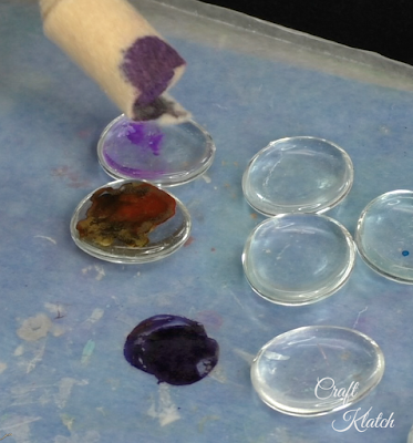 Dauber dabbing a glass gem with purple alcohol ink