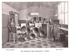 Luigi Russolo (left), his fellow Futurist Ugo Piatti, and a  collection of the intonarumori machines he used for his music
