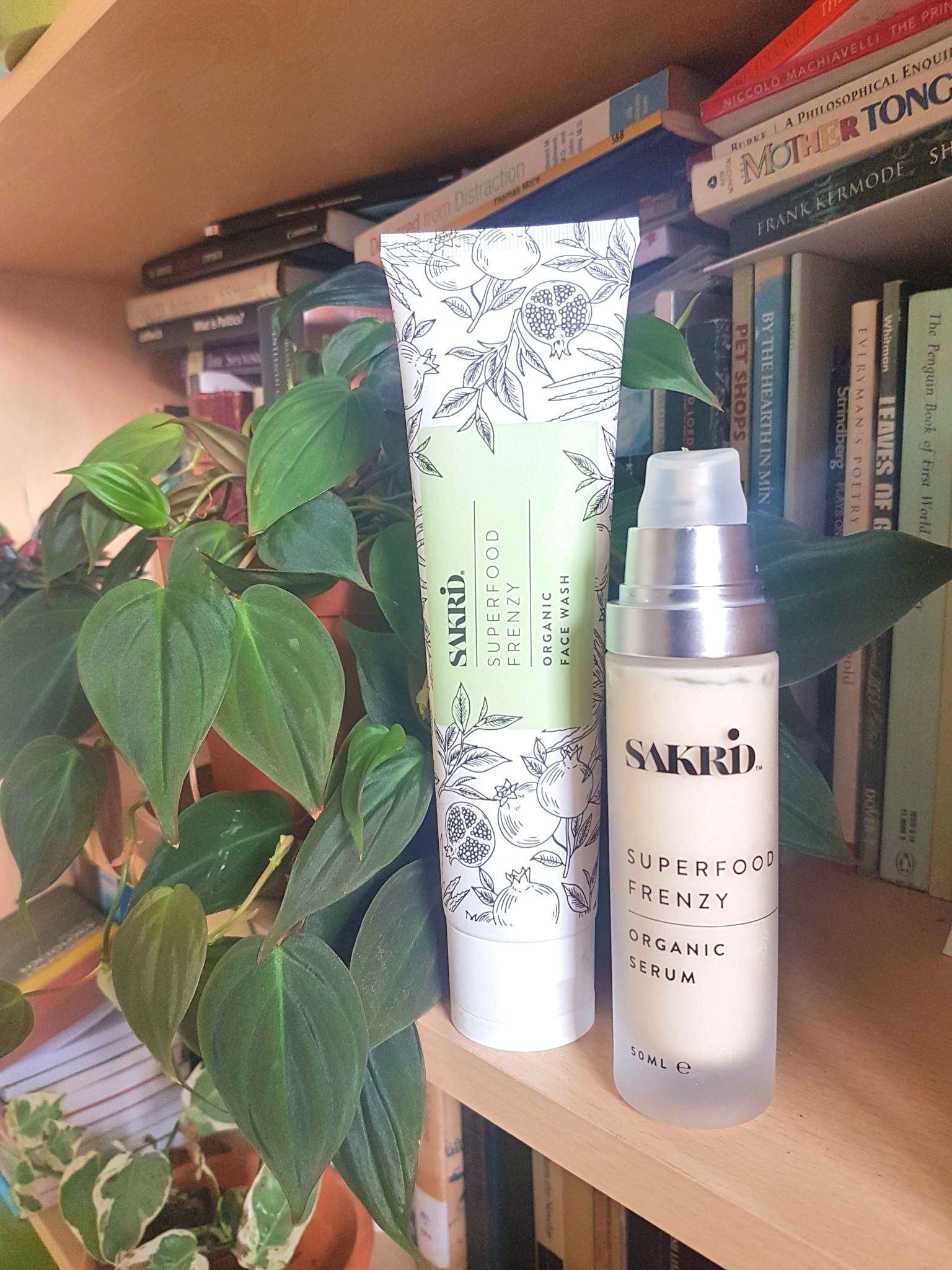 Sakrid Beauty Superfood Frenzy Organic Face Wash and Serum on a bookshelf with books and plants