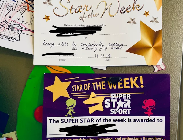 2 certificates on a fridge saying star of the week