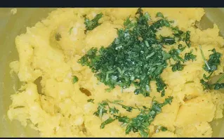 Mixing corriander leaves with potato fillings for bread pakora recipe