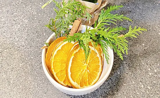 cut orange slices in a bowl with greens