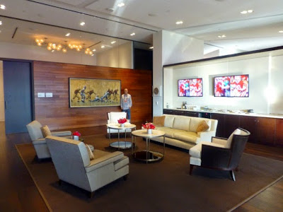 Levi Stadium owner's suite showing a NFL San Francisco 49er;s football art painting with the sports artist John Robertson standing next to his painting.