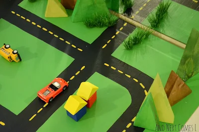 Block houses, cars, and homemade wooden trees on DIY road table from And Next Comes L
