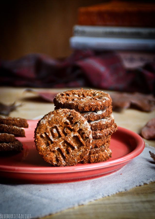 Galletas caseras sobre plato cerámica rojo, fondo madera oscuro, manzanas rojas, hojas secas otoño, paño de lino beige