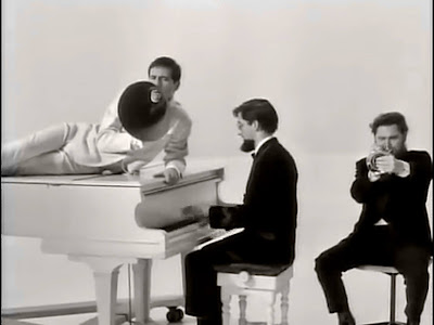 The Temperance Seven lead singer lounges on a piano singing into a megaphone .
