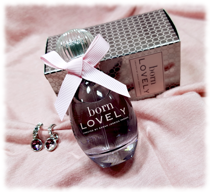 Angled view of Born Lovely bottle, box and pink earrrings.