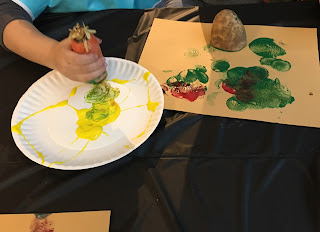 child painting with carrots and a potato