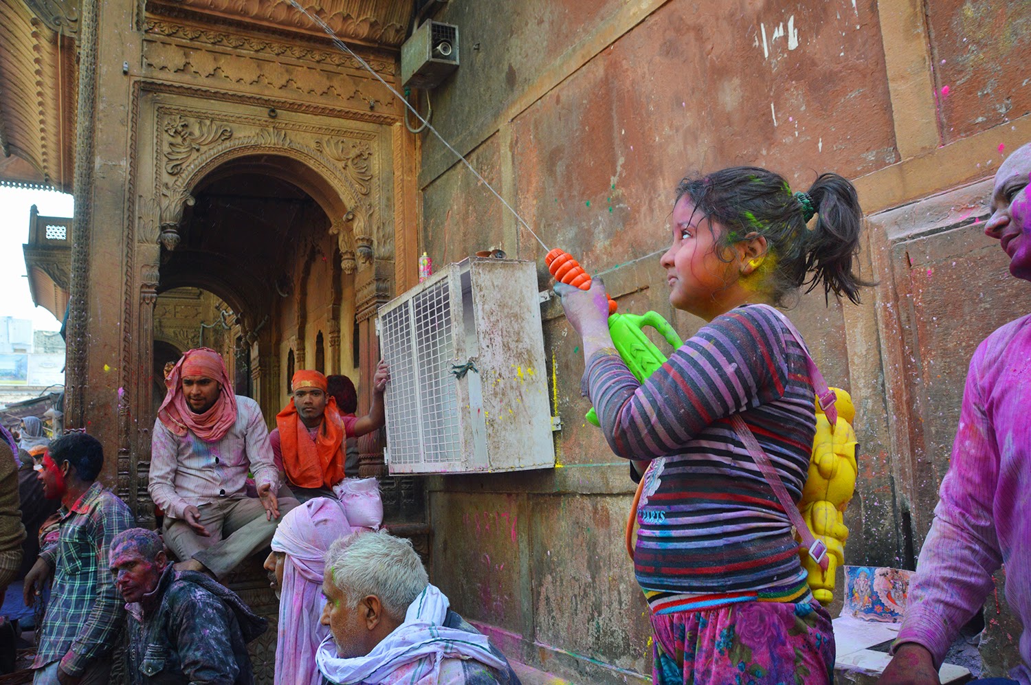 Small girl playing holi Holi Banke Bihari Temple Vrindavan 2015 colors gulal red yellow green men 