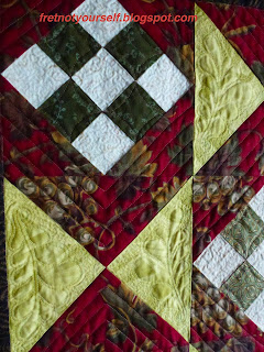 Feathers, parallel lines, and stippling are highlighted in this quilt detail.