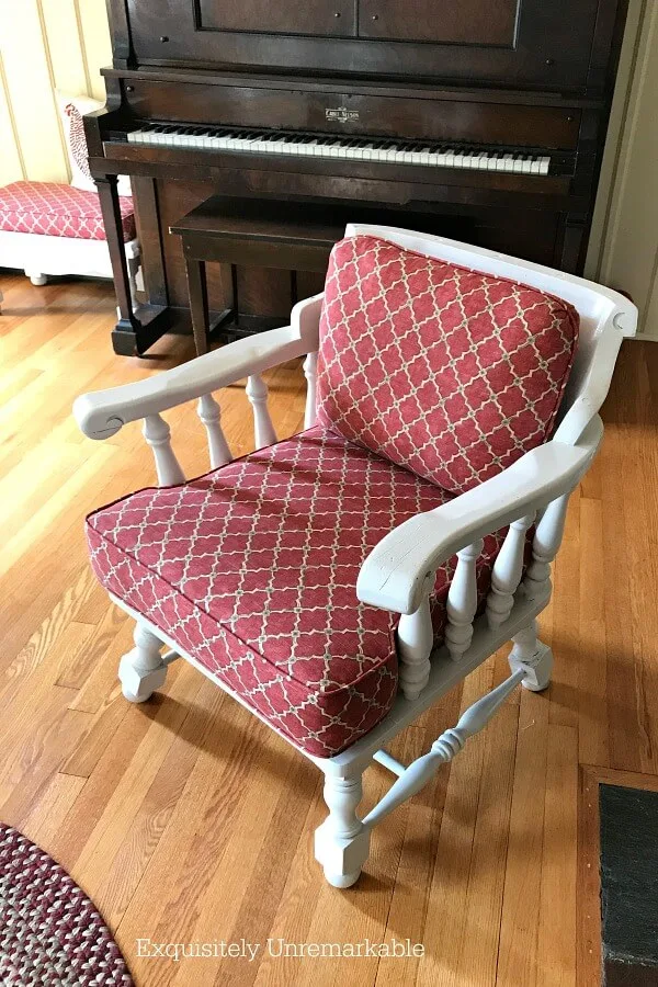 Painted Wooden Captain's Chair with red fabric cushions in a living room