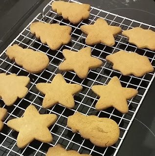 Christmas biscuits cooling on a rack, as an activity for children and frugal present.