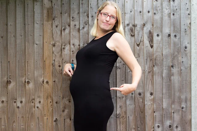 Pregnant me pointing at my pelvic region to show where I get PGP pain in pregnancy.