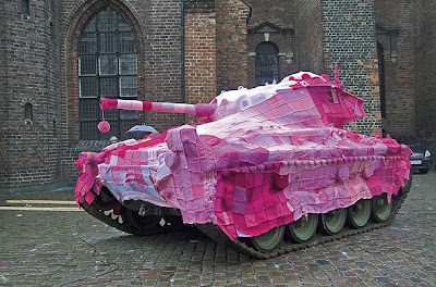 army tank covered in a large afghan crocheted in shades of pink