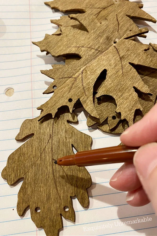 Drawing Veins On Wooden Leaves with brown marker