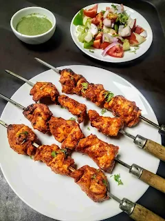 Serving chicken tikka kebab with green chutney and tossed salad