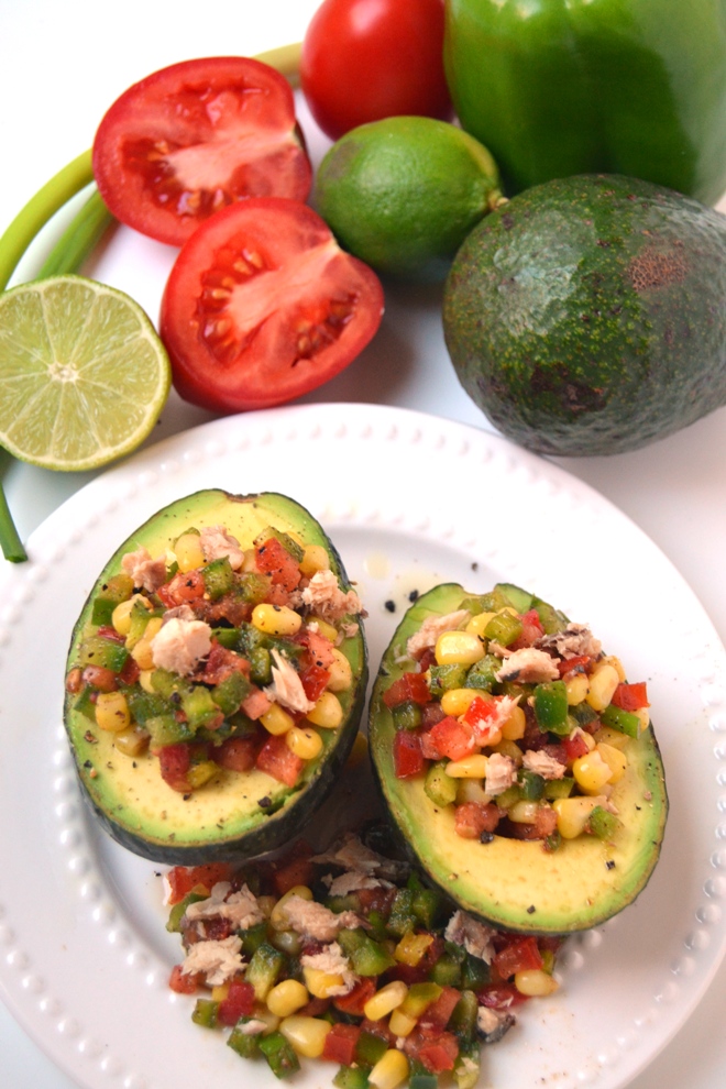 Mexican Sardine Salad Stuffed Avocados features a sardine salad made with tomatoes, bell peppers, corn and green onion with a tangy vinaigrette stuffed in a ripe avocado for an easy, nutritious meal! www.nutritionistreviews.com