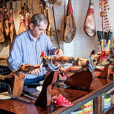 Owner of La Jamoneria carving ham in Zaragoza, Spain