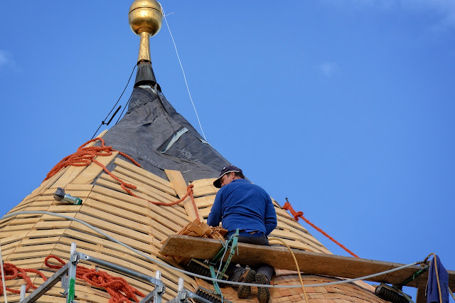 man repairing rooftop on a ladder - roofing tips for homeowners