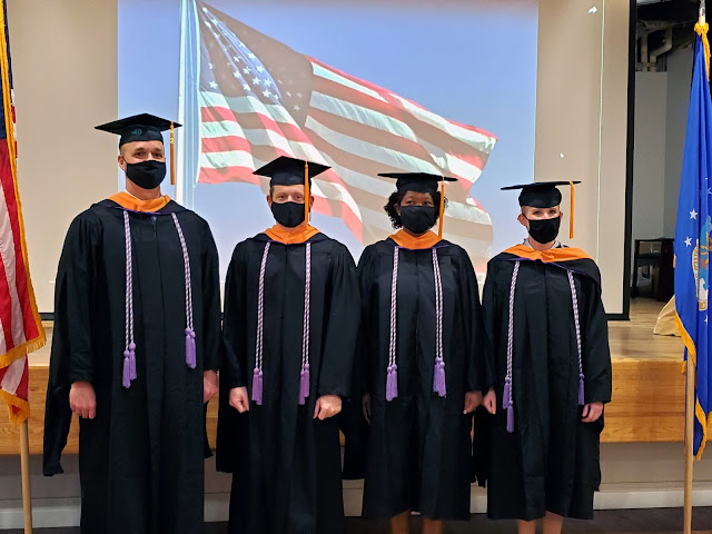 Four graduates standing side by side