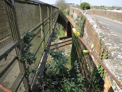 View between road bridge and footbridge, showing railway below.