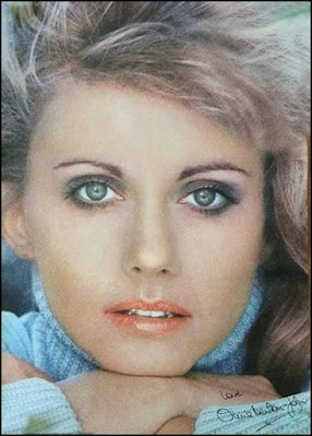 Olivia Newton-John poster face close-up on light blue background