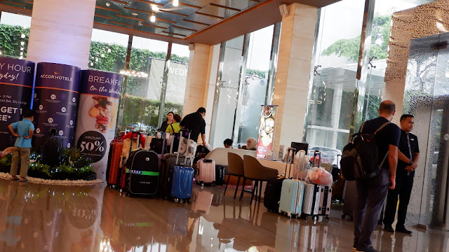 orang-orang membawa koper di lobi hotel grand mercure jakarta